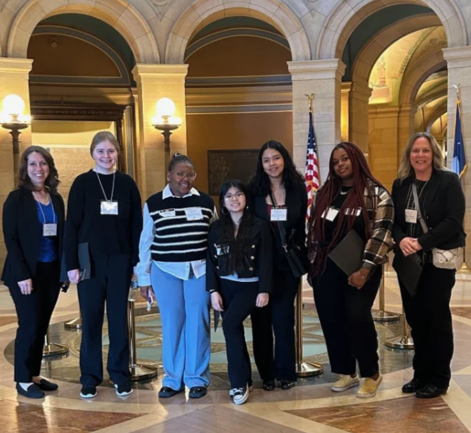 Five college students and two instructors on a classroom excursion stand in the rotunda of the Minnesota States Capitol building.